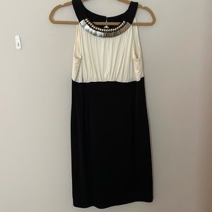 Black and white body con dress, with silver detailing on high neckline
